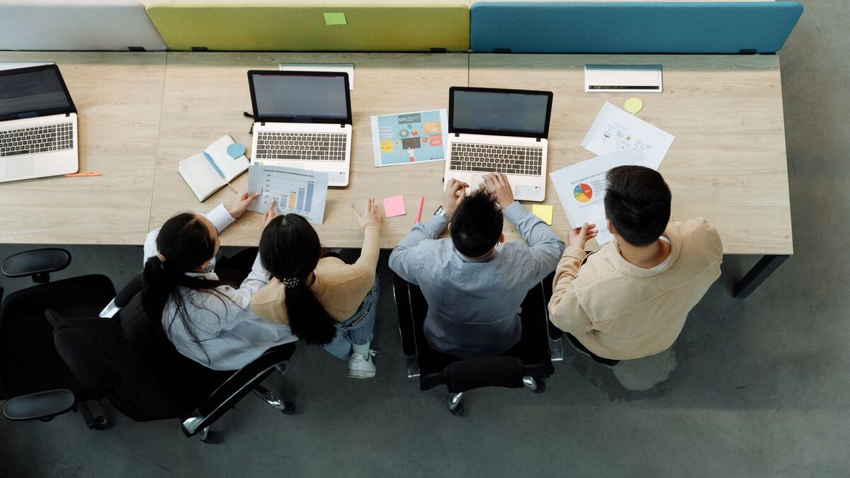 A small team working together around laptops, seen from above